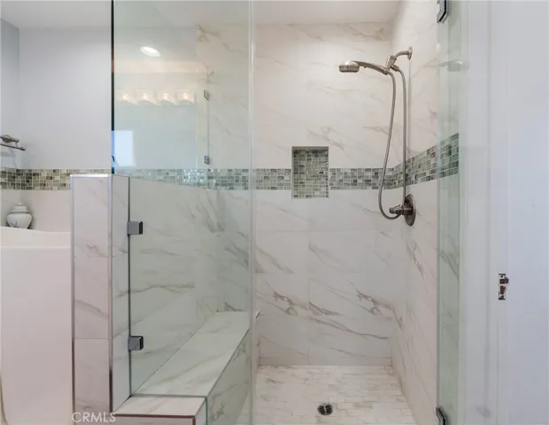 Remodeled walk-in shower with spacious design and soft ocean-inspired finishes—clean, modern, and relaxing.