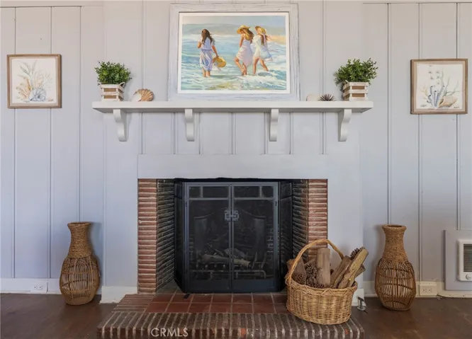 Charming wood-burning fireplace with coastal details, creating a warm and inviting focal point in the living room.