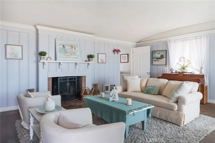 Cozy coastal living room with fireplace and soft natural light. Inviting space with beach-inspired finishes and a relaxed, comfortable feel.