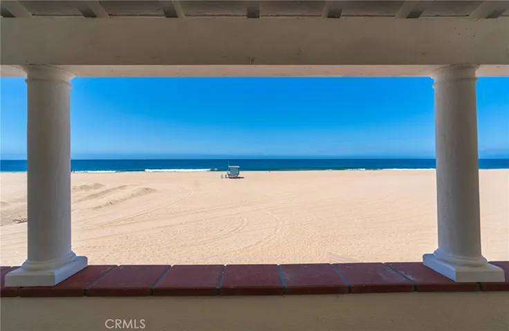 Framed ocean views from the primary bedroom, capturing the beach, waves, and open horizon.