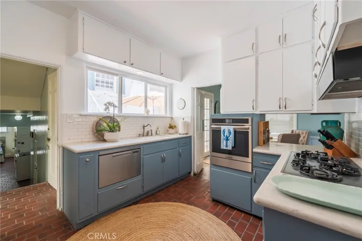 Light-filled kitchen with many new appliances, ample cabinetry, and easy access to patio—perfect for everyday living and entertaining.