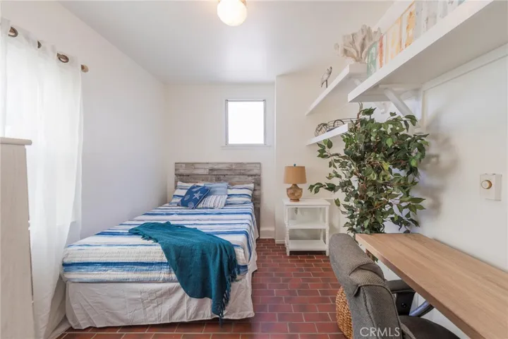 Cozy third bedroom with beach-inspired style, comfortable bed, and dedicated desk—perfect for guests, teens, or a quiet work-from-home space.