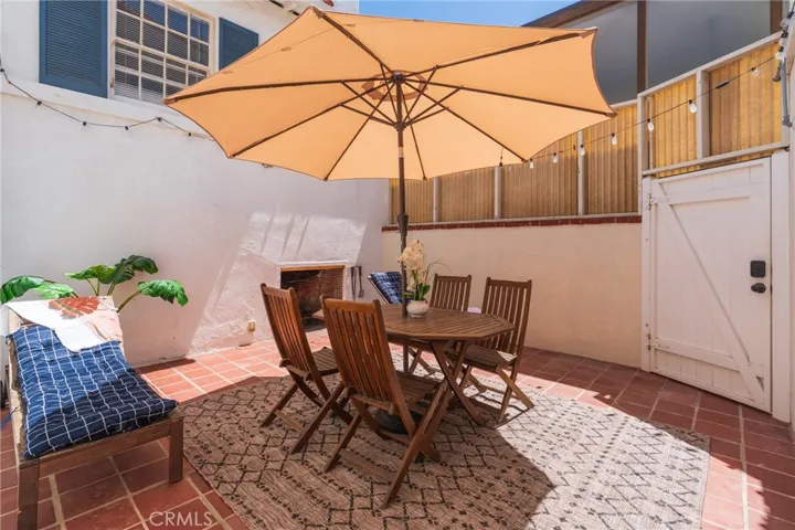 Private outdoor patio with dining area—ideal for sunbathing privately or enjoying romantic nights under the stars by the fireplace.