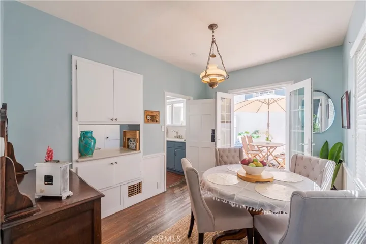 Charming dining area with built-in cabinetry, warm wood floors, and French doors opening to a private patio—perfect for indoor-outdoor entertaining.