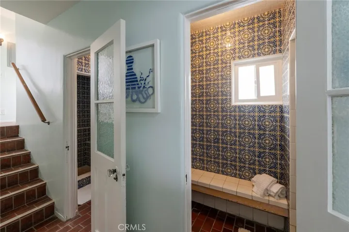 Just off the kitchen and next to the third bedroom, side entrance with two showers featuring imported Spanish tile and a 1/4 bath—perfect for keeping the home sand free.
