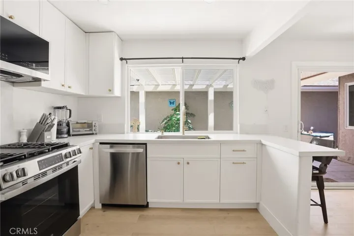 Beautiful and Large White Kitchen with Large Window Facing Back Patio