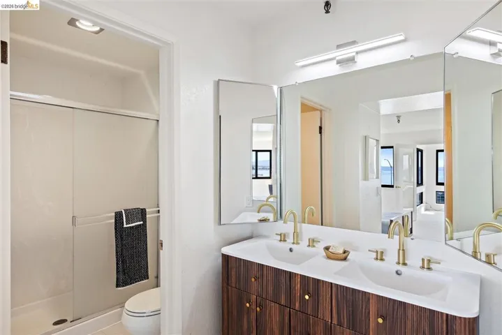 Bathroom with double vanity, a stall shower, and ensuite bathroom