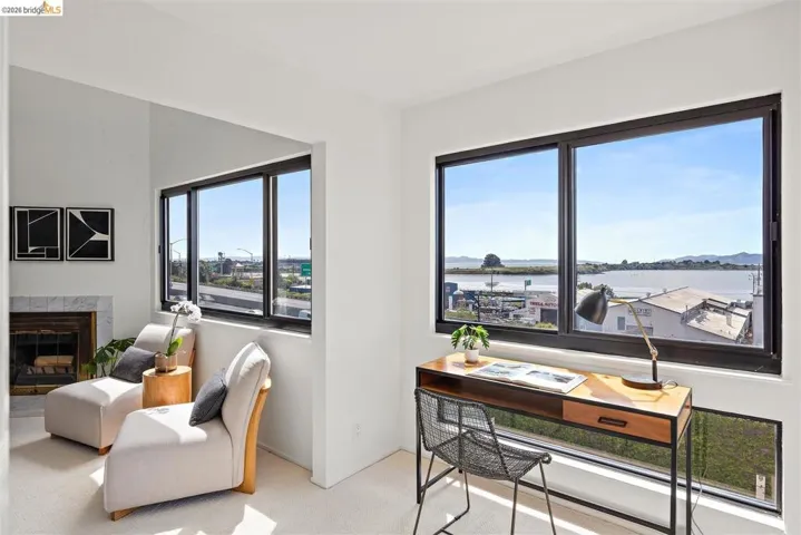 Office featuring light colored carpet, a fireplace, and a water view