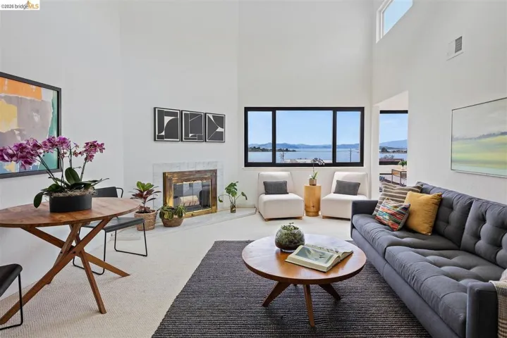 Carpeted living area featuring a high end fireplace, a mountain view, and a high ceiling
