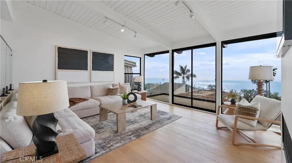 Light-filled living room with an open and airy feel, showcasing ocean and white-water views
