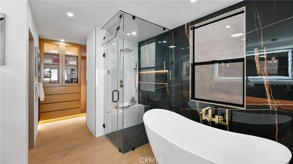 Spa-like primary bathroom with steam shower, dual custom vanity sinks, and designer finishes.
