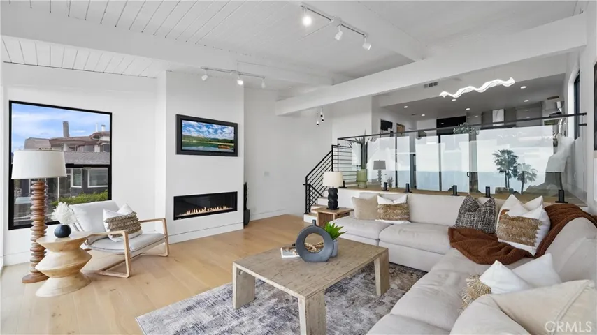 Light-filled living room with an open and airy feel, showcasing ocean and white-water views.