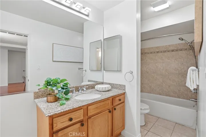 Full-size bathroom featuring a separate enclosed area for the toilet and tub/shower, offering added privacy and functionality.