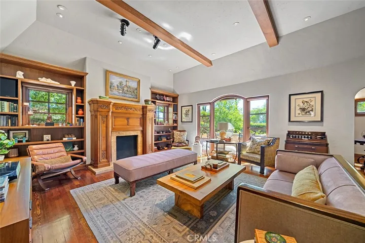 Elegance and comfort abound in this lovely living room with high beamed ceilings and perfectly placed lighting to accent any art one may have for display. Large picture window faces the front yard with privacy hedges.