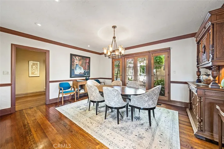 This dining room is lovely and inviting with subtle lighting situated perfectly to accent artwork and decor. An antique German hutch has a pass through to the kitchen. Throughway to the left of the image leads to 3 out of 4 bedrooms and 2 out of 5 bathrooms.