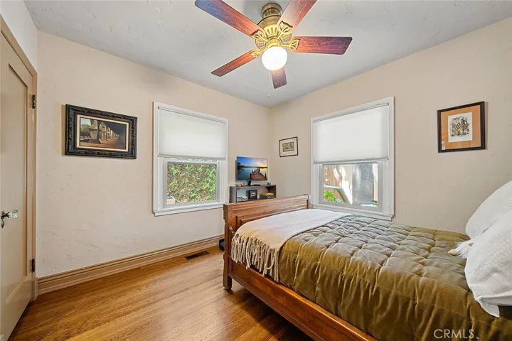 Two of four bedrooms with wood flooring and ceiling fan. This room is facing the side and backyard.