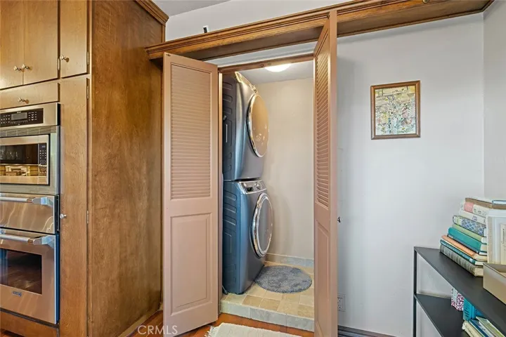 Stackable laundry remains and situated across from the breakfast area in the kitchen.
