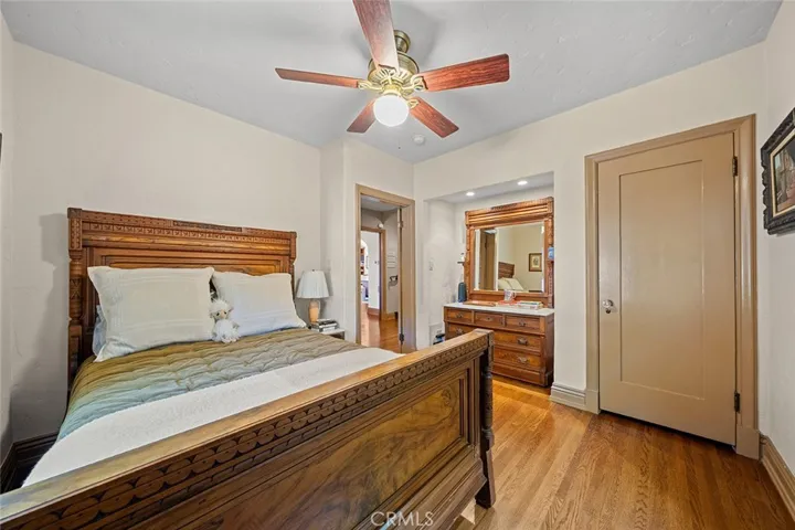 Two of four bedrooms with wood flooring and inlet that has recessed lighting with room to place a dresser next to the closet.