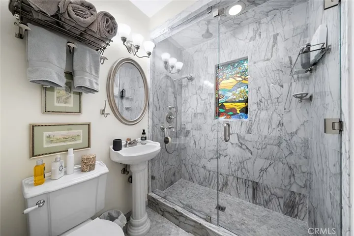 Lower level 3/4 bathroom with a stained glass window adding character to this space located near the lower level two bedrooms.