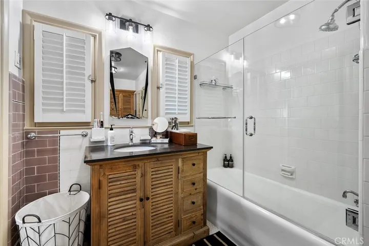 Primary en suite with walk in closet. The enclosed shelving unit remains and is a perfect place for linens and toiletries.