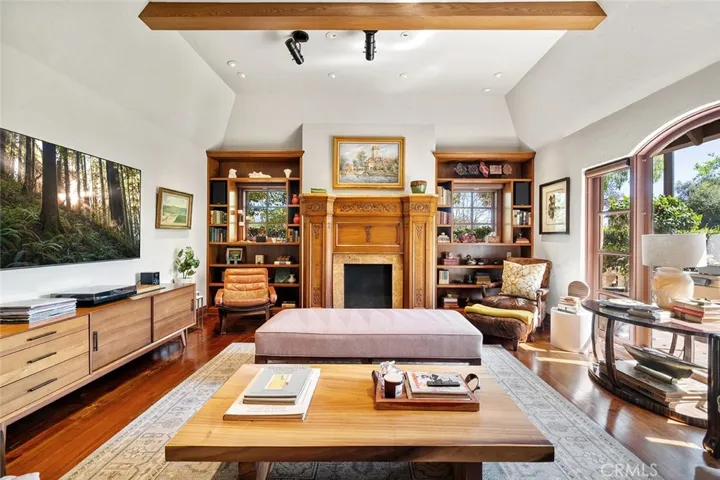 Simply gorgeous and elegant. Living room with built in shelves set with built in speakers frames the history of the fireplace mantle from Normandy.