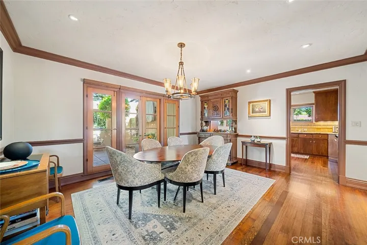 This dining room is lovely and inviting with subtle lighting situated perfectly to accent artwork and decor. An antique German hutch has a pass through to the kitchen.