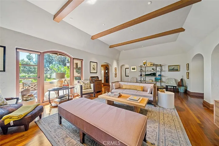 Elegance and comfort abound in this lovely living room with high beamed ceilings and perfectly placed lighting to accent any art one may have for display. Large picture window faces the front yard with privacy hedges.