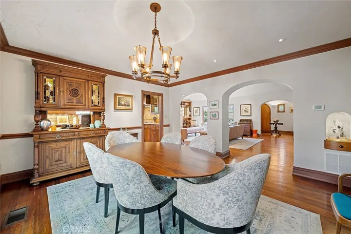 This dining room is lovely and inviting with subtle lighting situated perfectly to accent artwork and decor. An antique German hutch has a pass through to the kitchen.