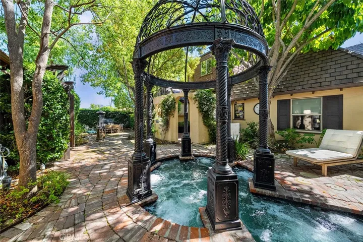 Gazebo accenting a large hot tub set between the gym and the home.