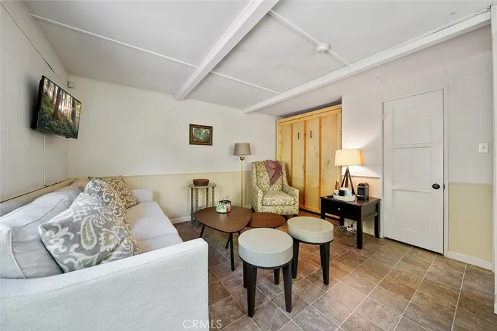 Upstairs apartment includes Murphy bed, couch, chair, built in desk adn small refrigerator.