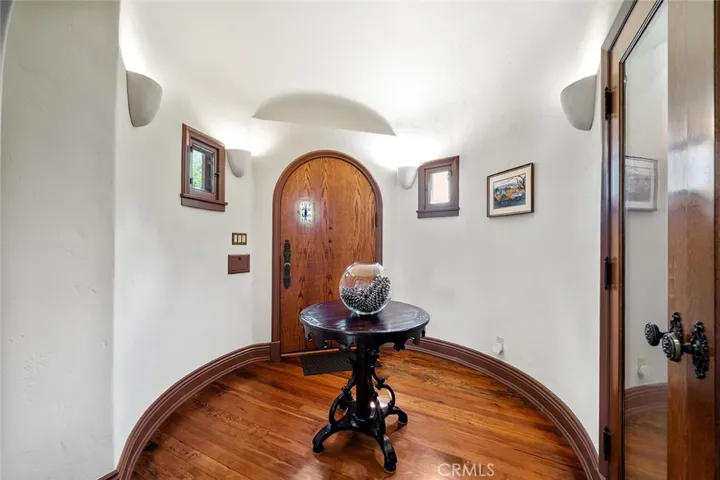 Formal entrance with wine cellar (right of image) Arched wooden door with peek a boo window adds to the charm and lines of this entry.
