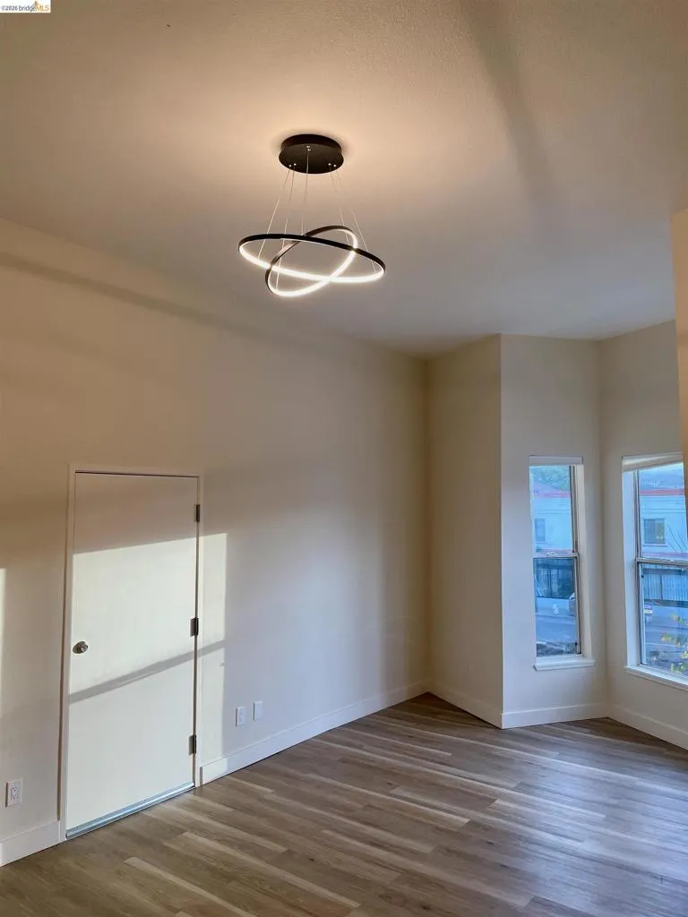 Empty room featuring dark wood finished floors and baseboards