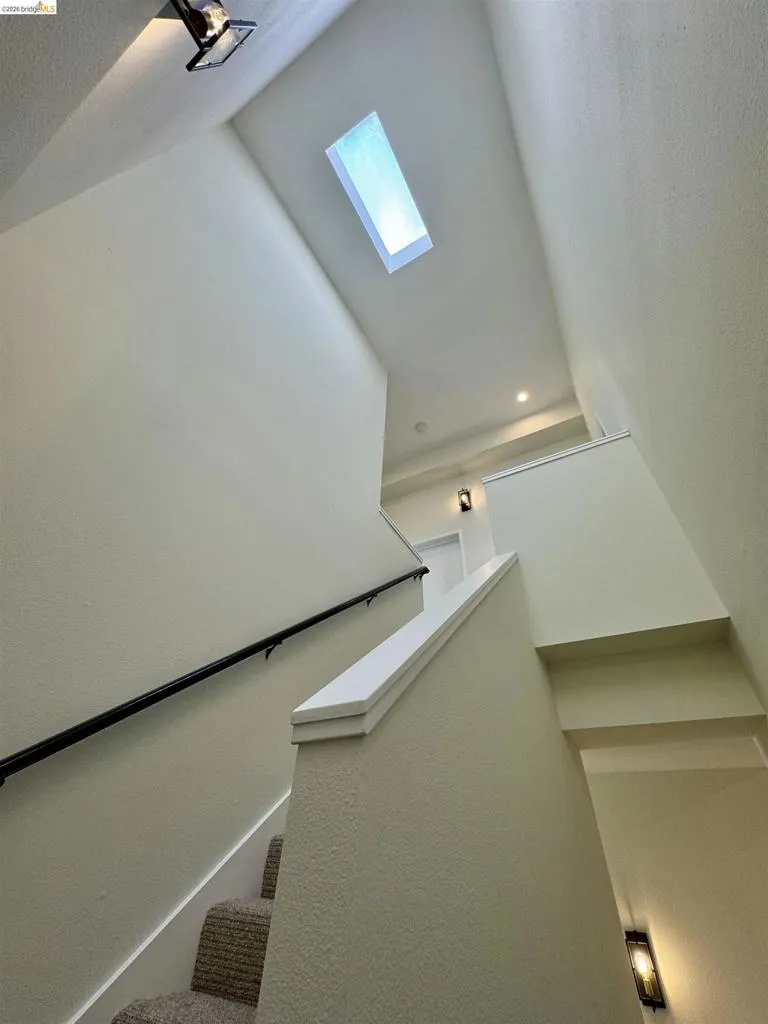 Staircase featuring a skylight and a textured ceiling