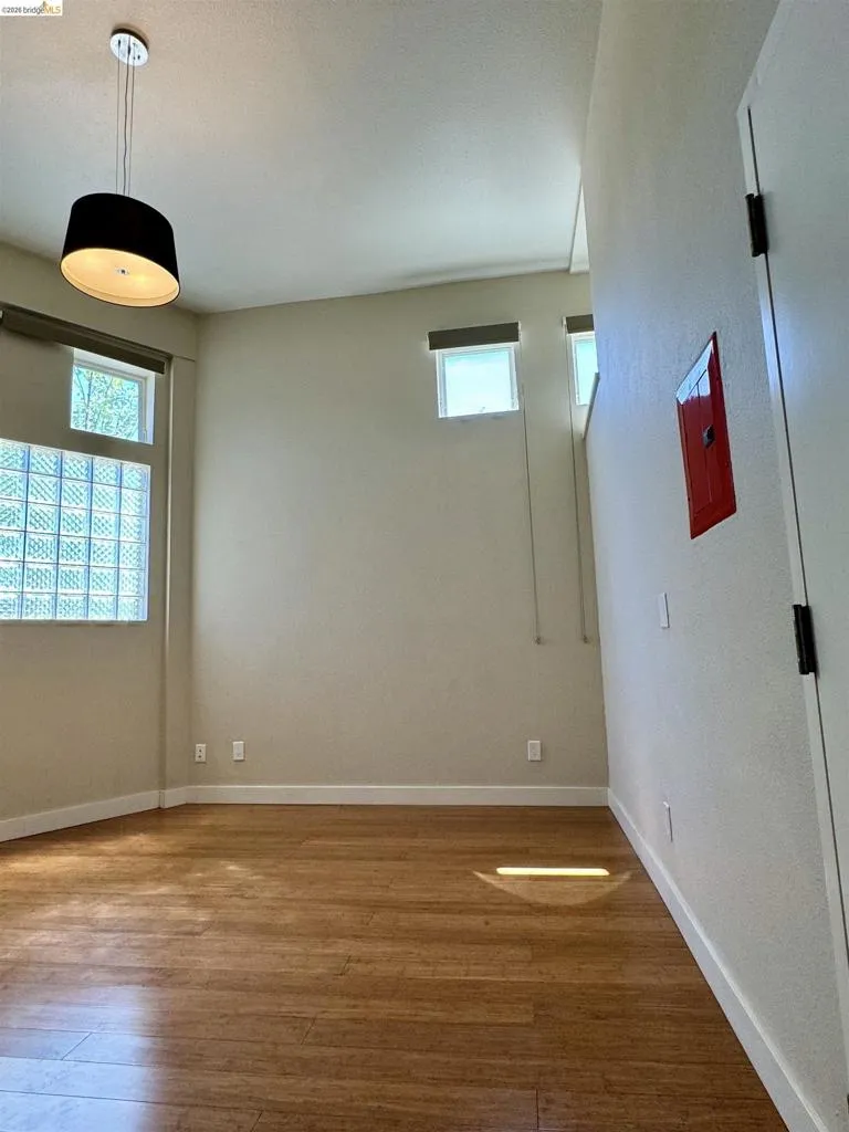 Empty room with wood finished floors and electric panel