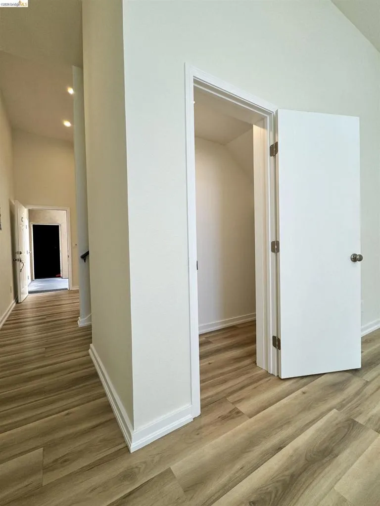 Hallway with light wood-type flooring and recessed lighting