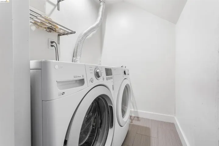 Laundry room featuring lofted ceiling and washer and clothes dryer