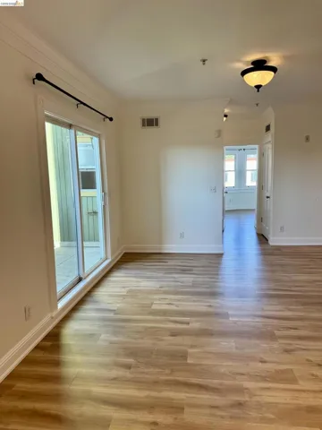 Spare room featuring light wood-style floors and crown molding