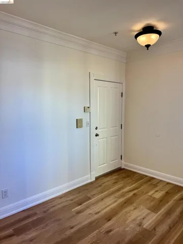 Unfurnished room with ornamental molding and dark wood-style floors