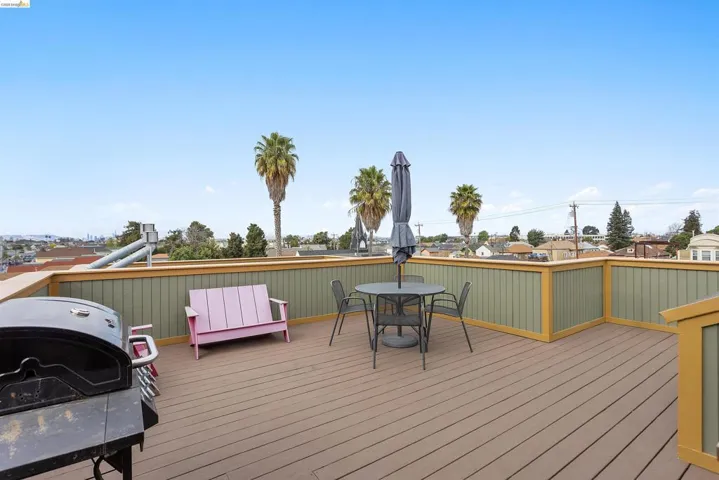 Wooden deck with a residential view, a grill, and outdoor dining area