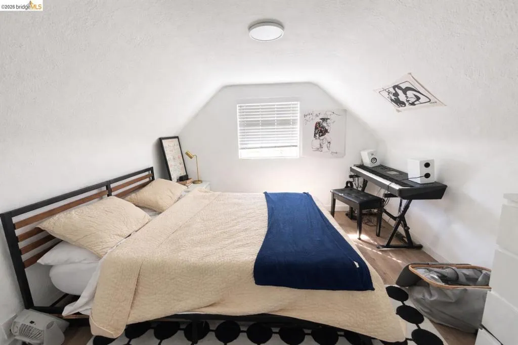Bedroom with wood finished floors and a textured ceiling