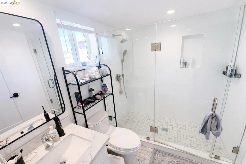 Full bathroom with vanity, recessed lighting, and a shower stall