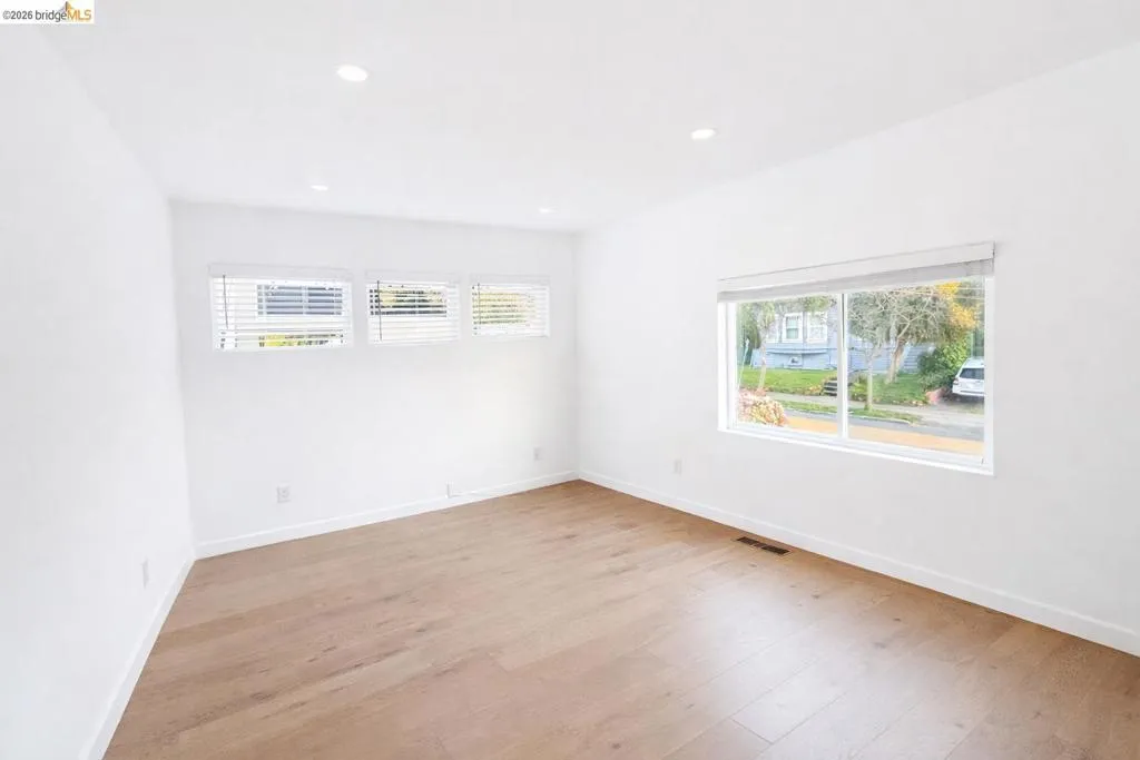 Empty room with light wood-type flooring and recessed lighting