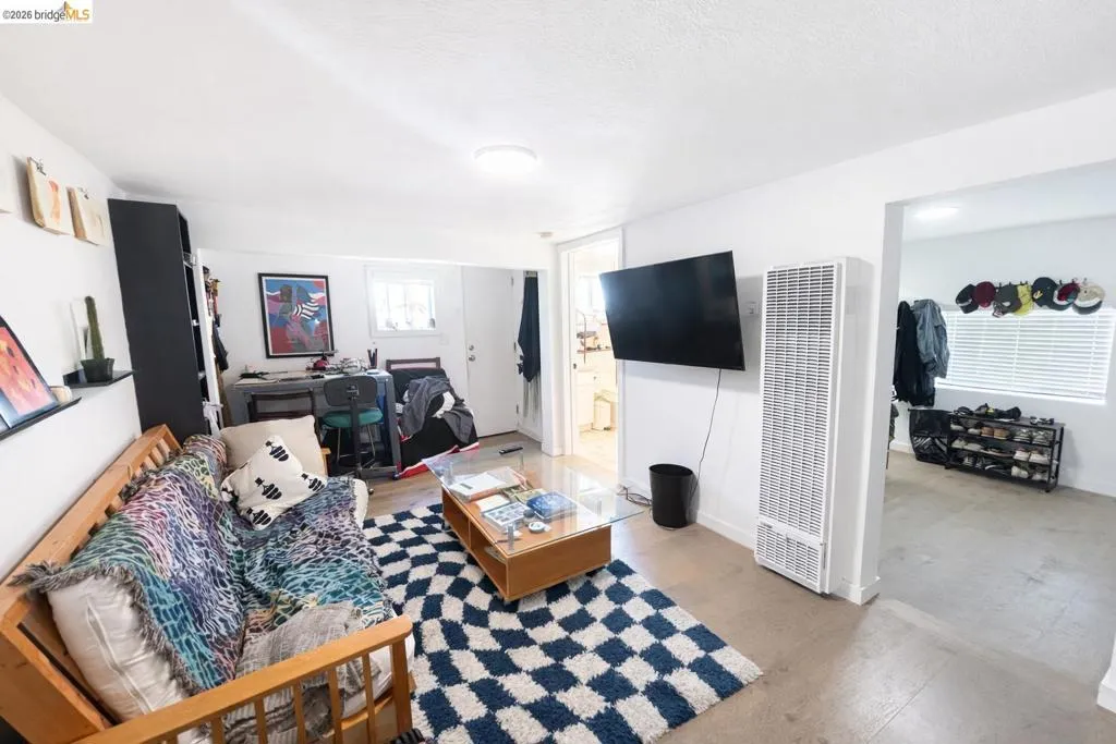 Living room with a heating unit and light wood-style flooring