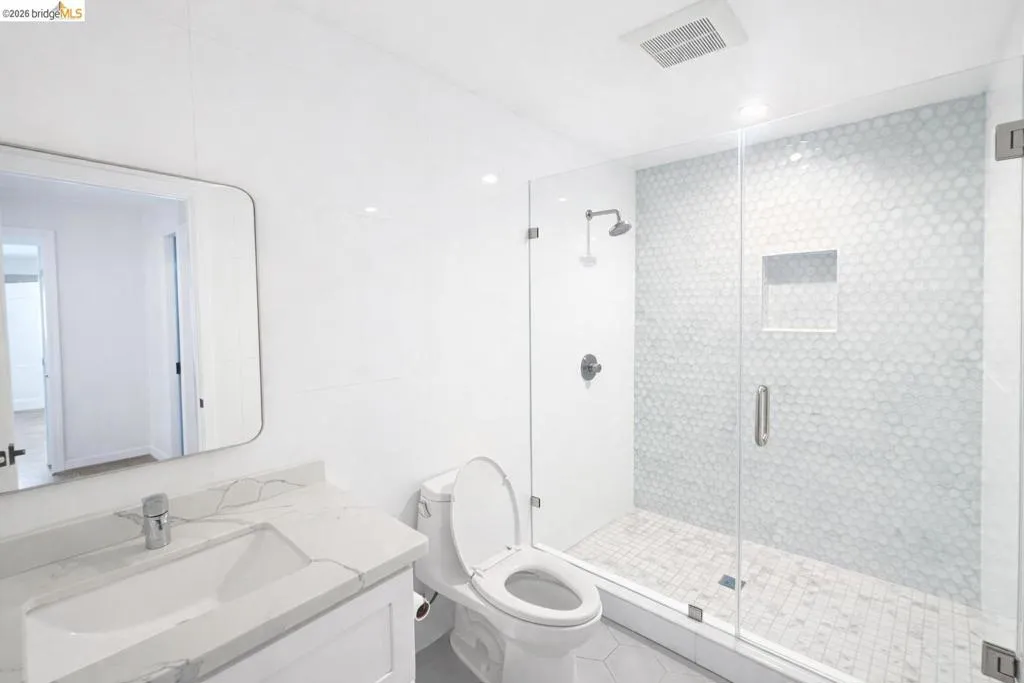 Bathroom featuring vanity, tile walls, and a shower stall
