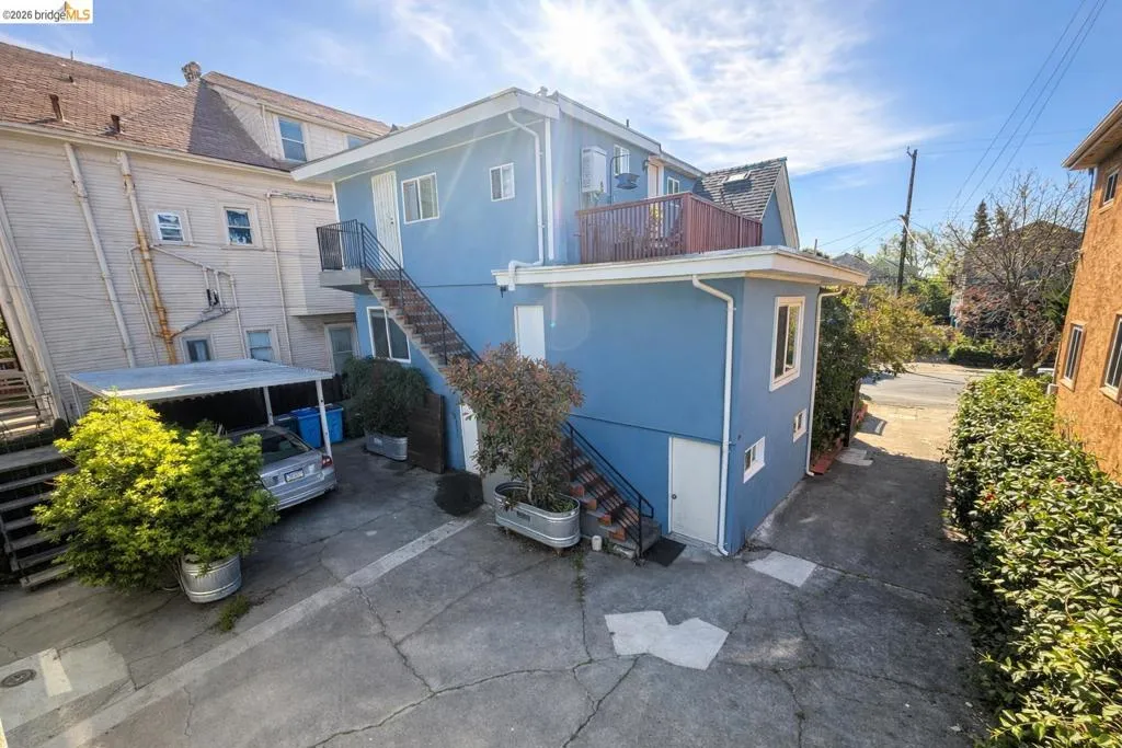 Rear view of property with stucco siding and a balcony