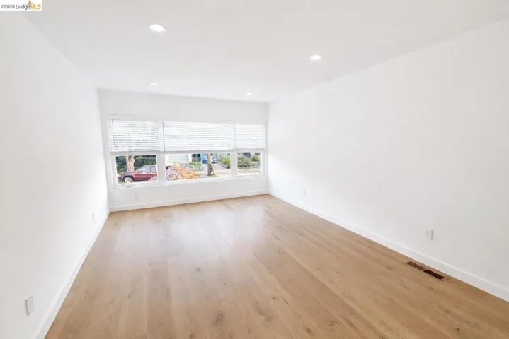 Empty room with light wood-style flooring and recessed lighting