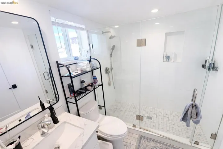 Full bathroom with vanity, recessed lighting, and a shower stall