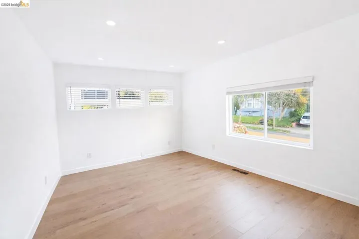 Empty room with light wood-type flooring and recessed lighting
