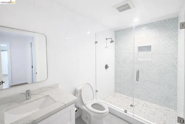 Bathroom featuring vanity, tile walls, and a shower stall