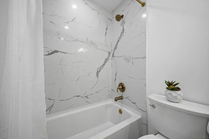 Modern upgraded bathroom with quartz slab shower & in unit washer/dryer!